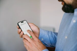 a man types in the whg phone number on his mobile phone dialler
